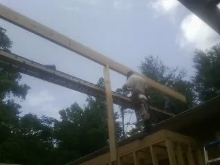Carpenter setting a ridge beam over a new addition frame — Ice Dam Removal by Roofing Brothers in Hickman