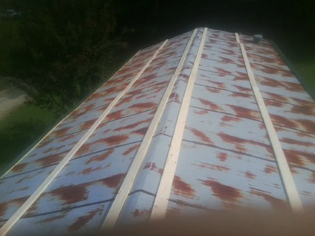 Rusted metal roof panels with new wood purlins before replacement — Storm Damage Roof Repair in Hickman by Roofing Brothers